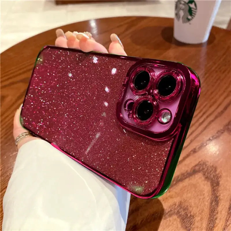 a woman holding a phone case with glitter on it