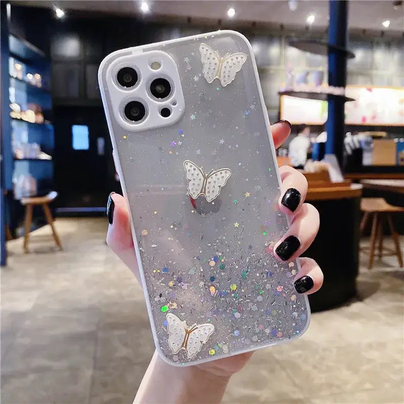 a woman holding a phone case with glitter and butterflies