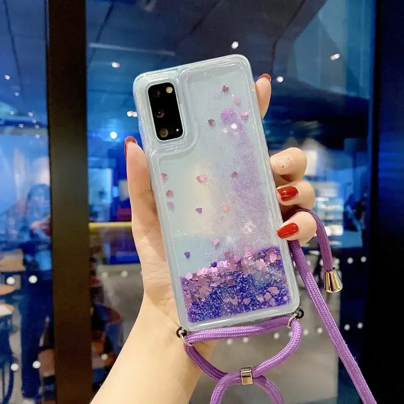 a woman holding a phone case with glitter and purple glitter