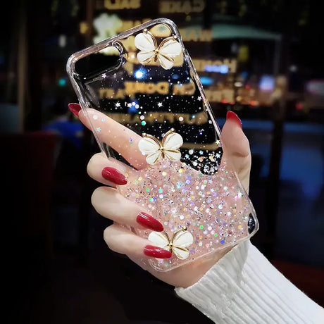 A woman holding a phone case with glitter butterflies