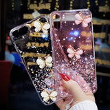 a woman holding a phone case with glitter butterflies