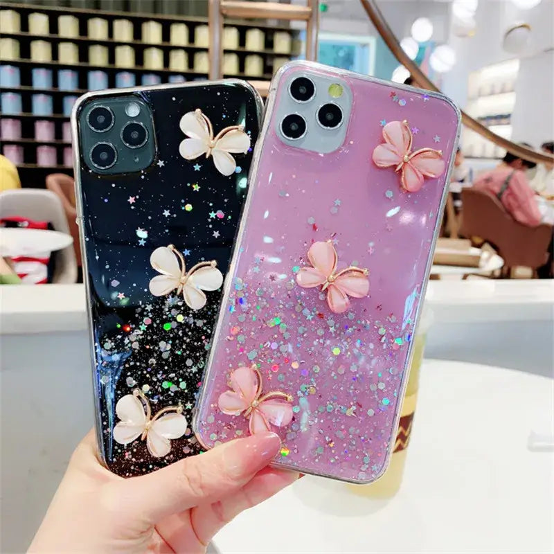 A woman holding a phone case with glitter butterflies