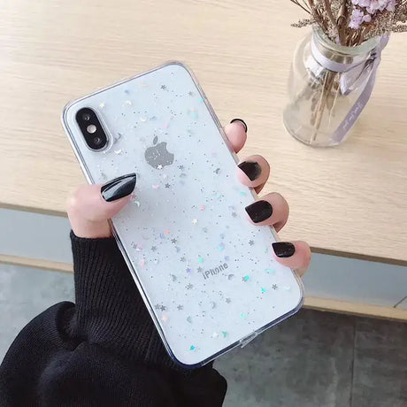 A woman holding a phone case with glitter stars on it