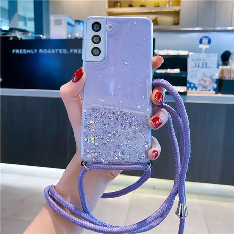 a woman holding a phone case with glitter on it