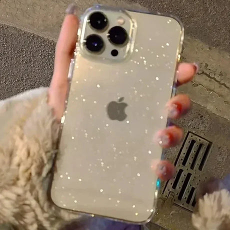 a woman holding a phone case with glitter on it