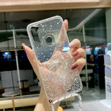 a woman holding up a phone case with glitter