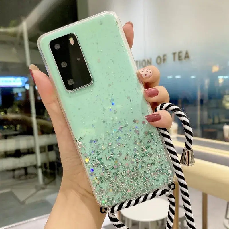 a woman holding a phone case with glitter and black and white stripes