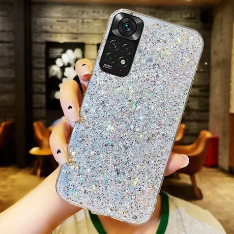 A woman holding up a phone case with glitter