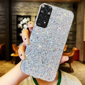 A woman holding up a phone case with glitter