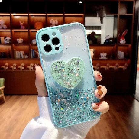 A woman holding a phone case with glitter heart