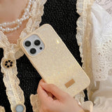 a woman holding a phone case with a gold glitter effect