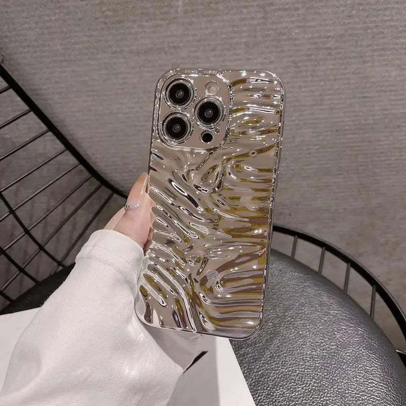 a woman holding a phone case with a gold foil effect