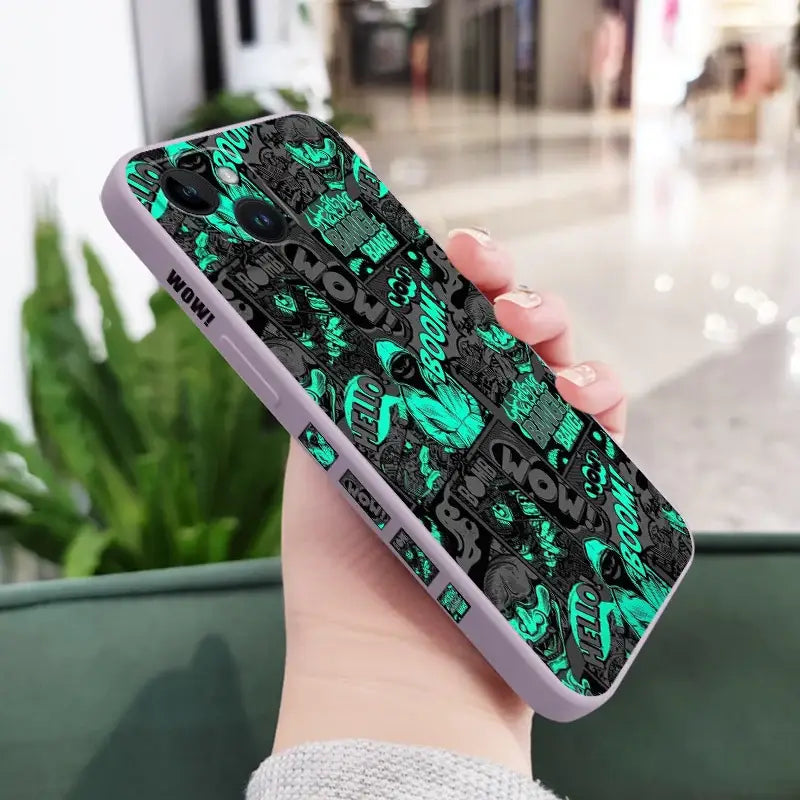 a woman holding a phone case with a green and black pattern