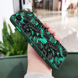 a woman holding a phone case with a green and black pattern