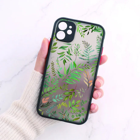 A woman holding a phone case with a green leaf pattern