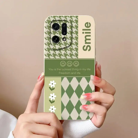 A woman holding up a phone case with a green and white pattern