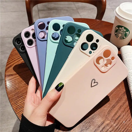 a woman holding a phone case with a heart on it