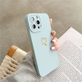 A woman holding a phone case with a heart on it