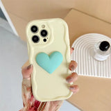 A woman holding a phone case with a heart on it