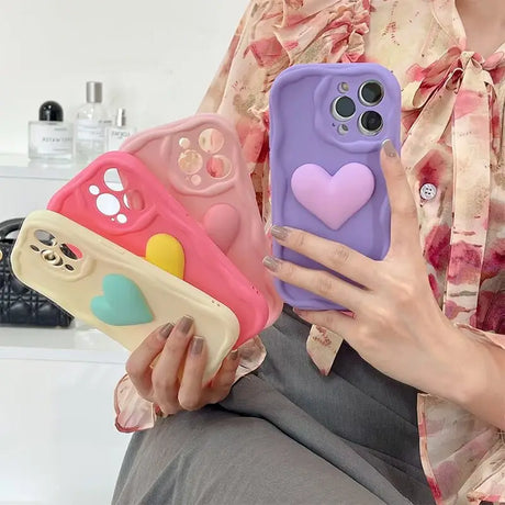 A woman holding a phone case with a heart on it