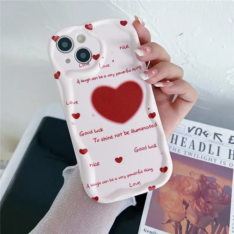 A woman holding a phone case with a heart on it