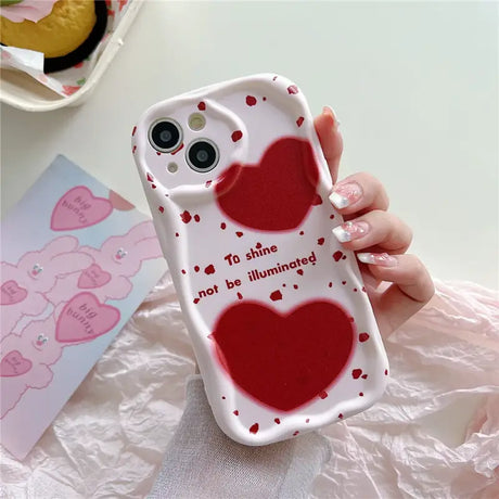 A woman holding a phone case with a heart on it