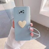 a woman holding a phone case with a heart on it