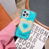 a woman holding a phone case with a heart on it