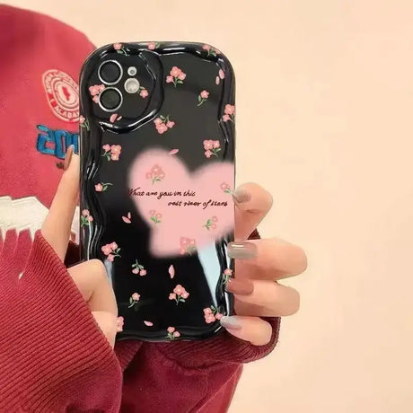 A woman holding a phone case with a heart design