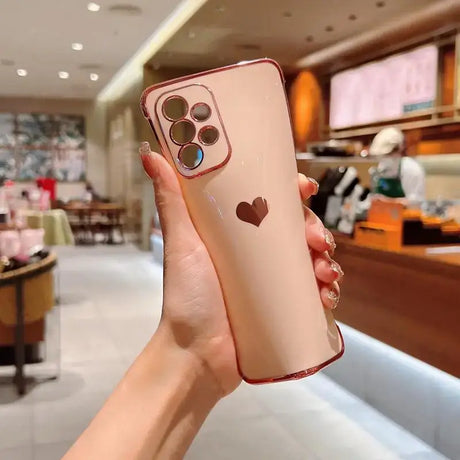 A woman holding up a phone case with a heart on it