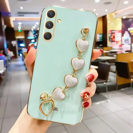 A woman holding a phone case with heart charms