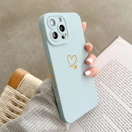 A woman holding a phone case with a heart on it