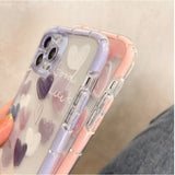 a woman holding a phone case with a heart pattern