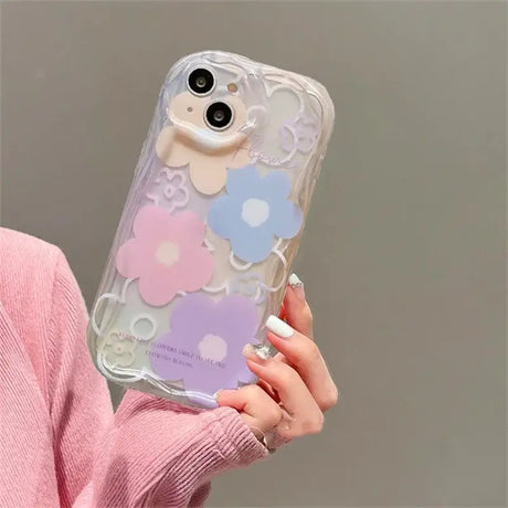 A woman holding a phone case with a heart pattern