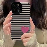 a woman holding up a phone case with a heart