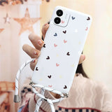 a woman holding a phone case with hearts on it