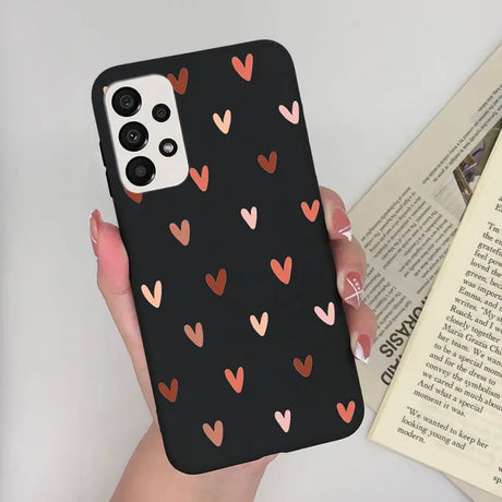 a woman holding a phone case with hearts on it