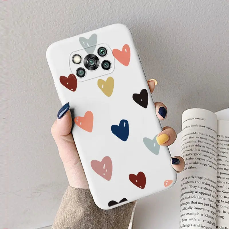 a woman holding a phone case with hearts on it