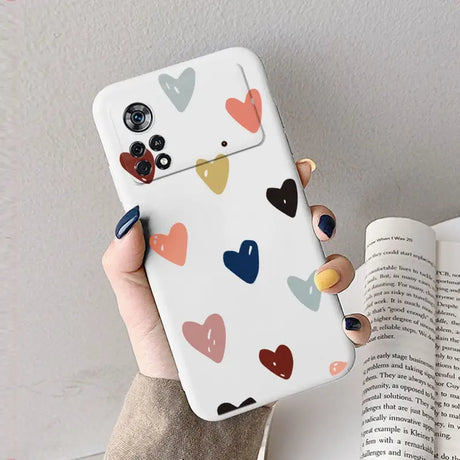 A woman holding a phone case with hearts on it