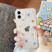 A woman holding a phone case with hearts on it