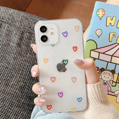 A woman holding a phone case with hearts on it