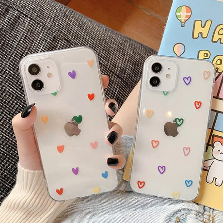 A woman holding a phone case with hearts on it