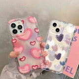 a woman holding a phone case with hearts on it