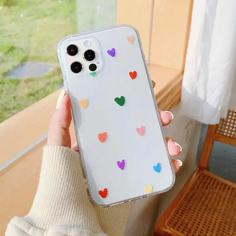 A woman holding a phone case with hearts on it