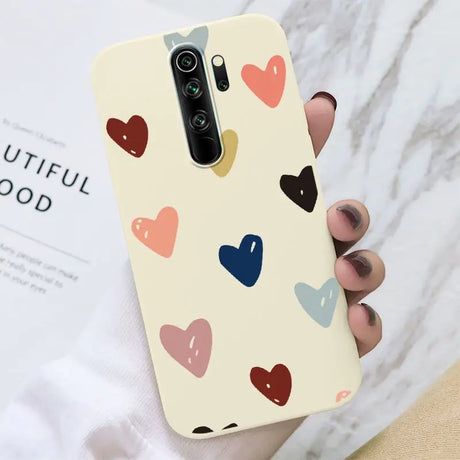 A woman holding a phone case with hearts on it