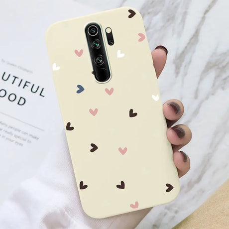 A woman holding a phone case with hearts on it