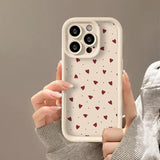 a woman holding a phone case with hearts on it