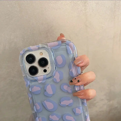 A woman holding a phone case with hearts on it