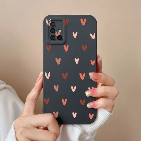 a woman holding a phone case with hearts on it