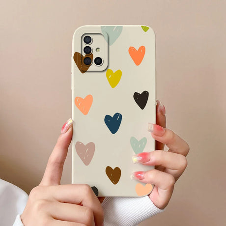 a woman holding a phone case with hearts on it